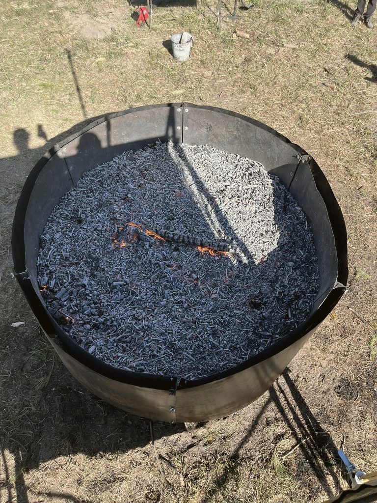 Levelled biochar bed inside a kiln ring, ready to be measured and sampled